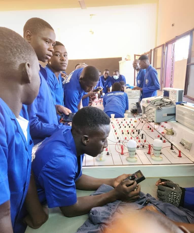Apprenants en électronique travaillant sur des bancs d'essai avec lampes et oscilloscopes