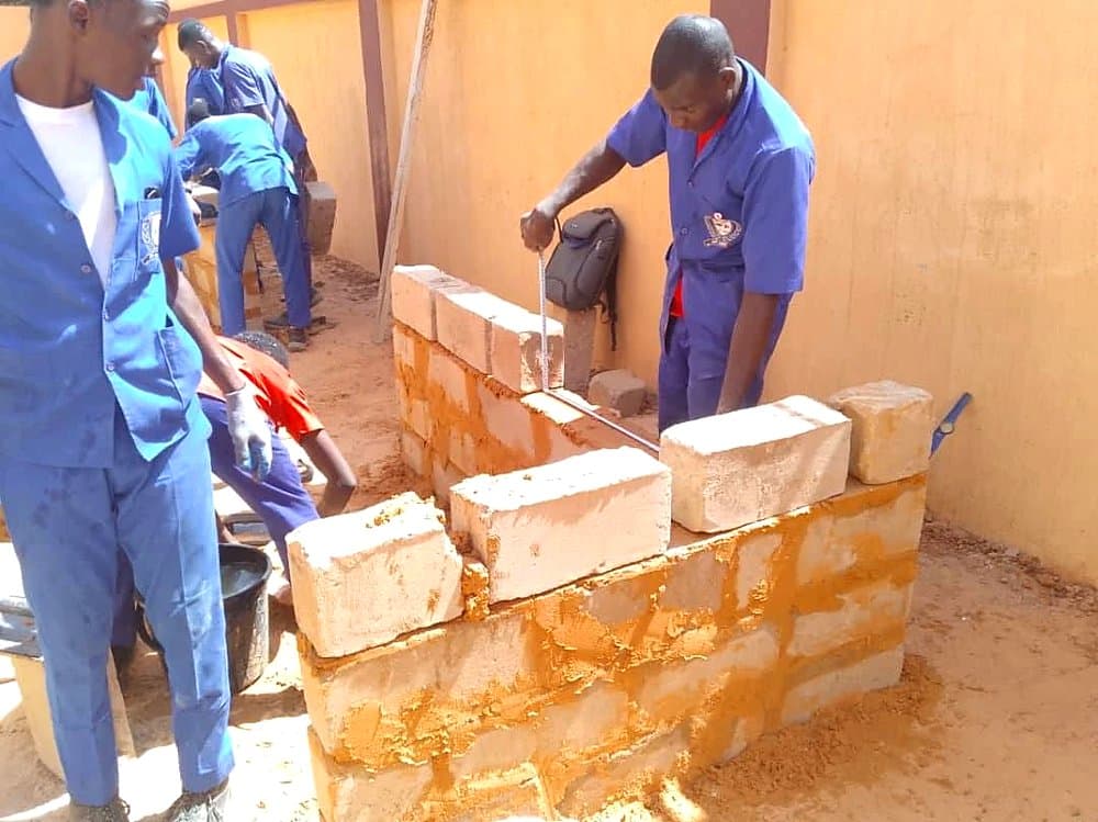 Apprenant prenant des mesures sur un mur en construction