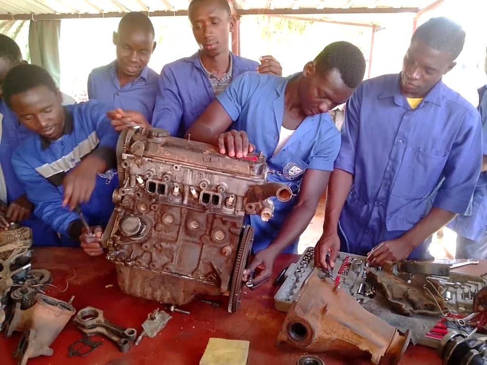 Apprenants en mécanique auto travaillant sur un bloc moteur