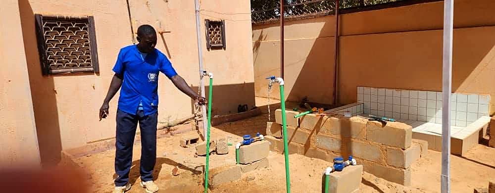 Formateur testant l'écoulement d'eau sur une installation de plomberie